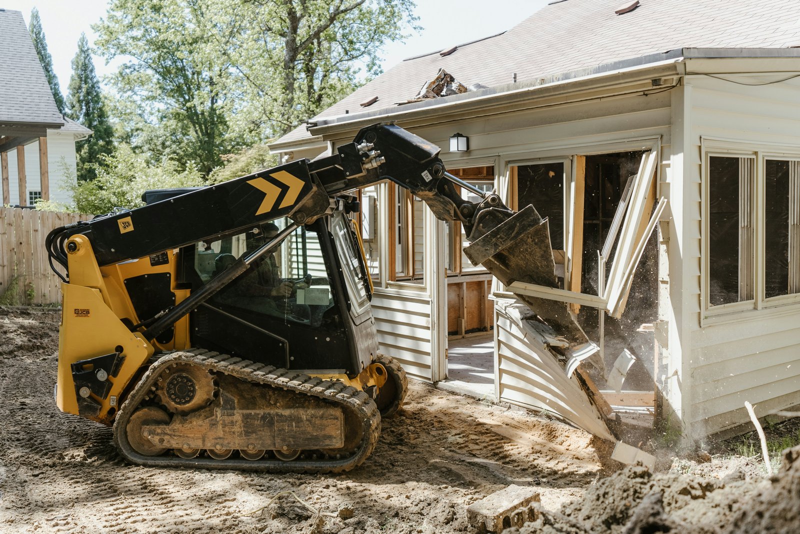 Compact-track skid steer grading a residential lot in Winnipeg
